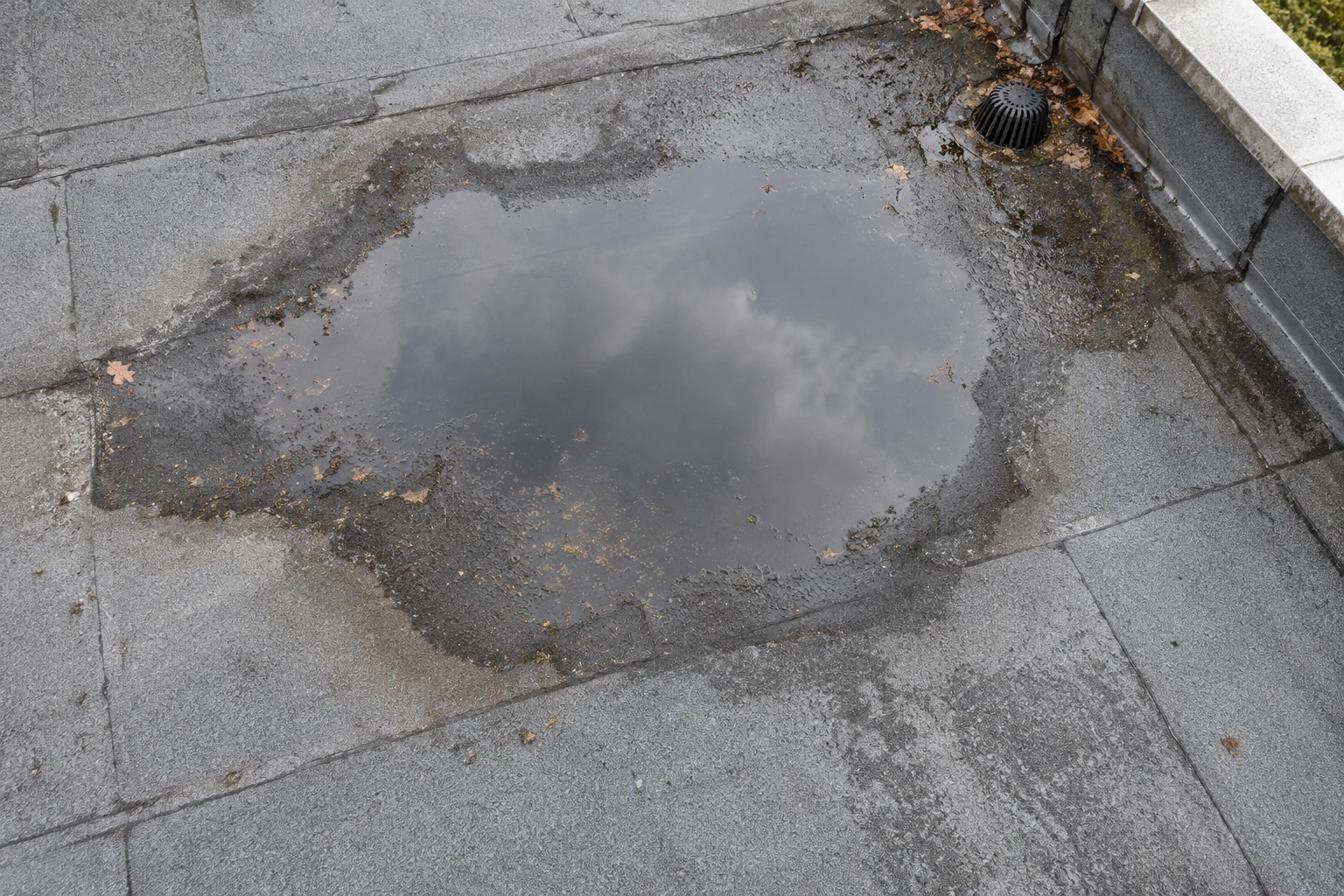 Illustration générée d’une toiture-terrasse avec membrane : une nappe d’eau occupe une zone du revêtement près d’une évacuation.